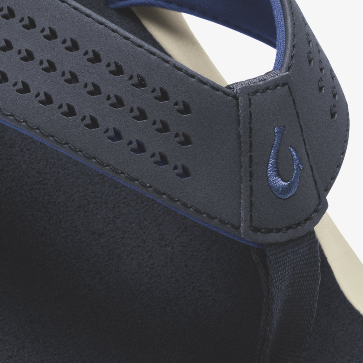 Dark blue slip-on shoe with perforated upper, blue accent trim, and embroidered logo detail on the side.