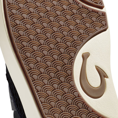 Brown and cream leather shoe sole with scalloped wave pattern and embossed hook symbol.
