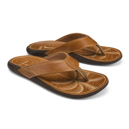 Pair of tan leather flip-flops with black soles and decorative carved footbeds featuring fox designs.