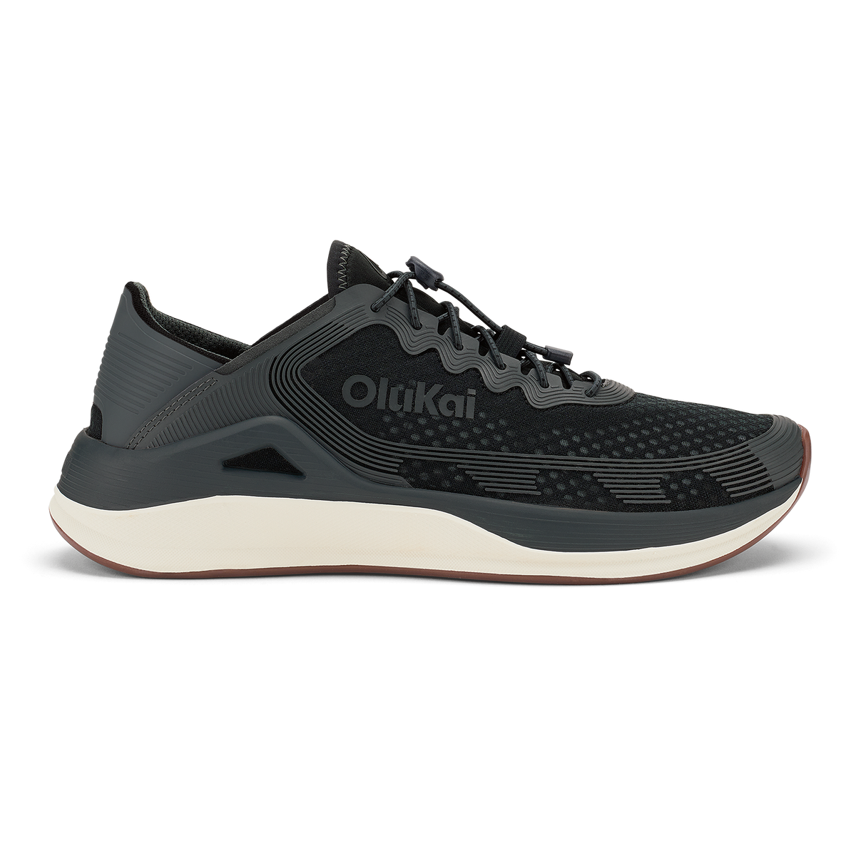 Black Olukai ʻAhi athletic shoe with cream midsole and textured upper, shown in profile view.