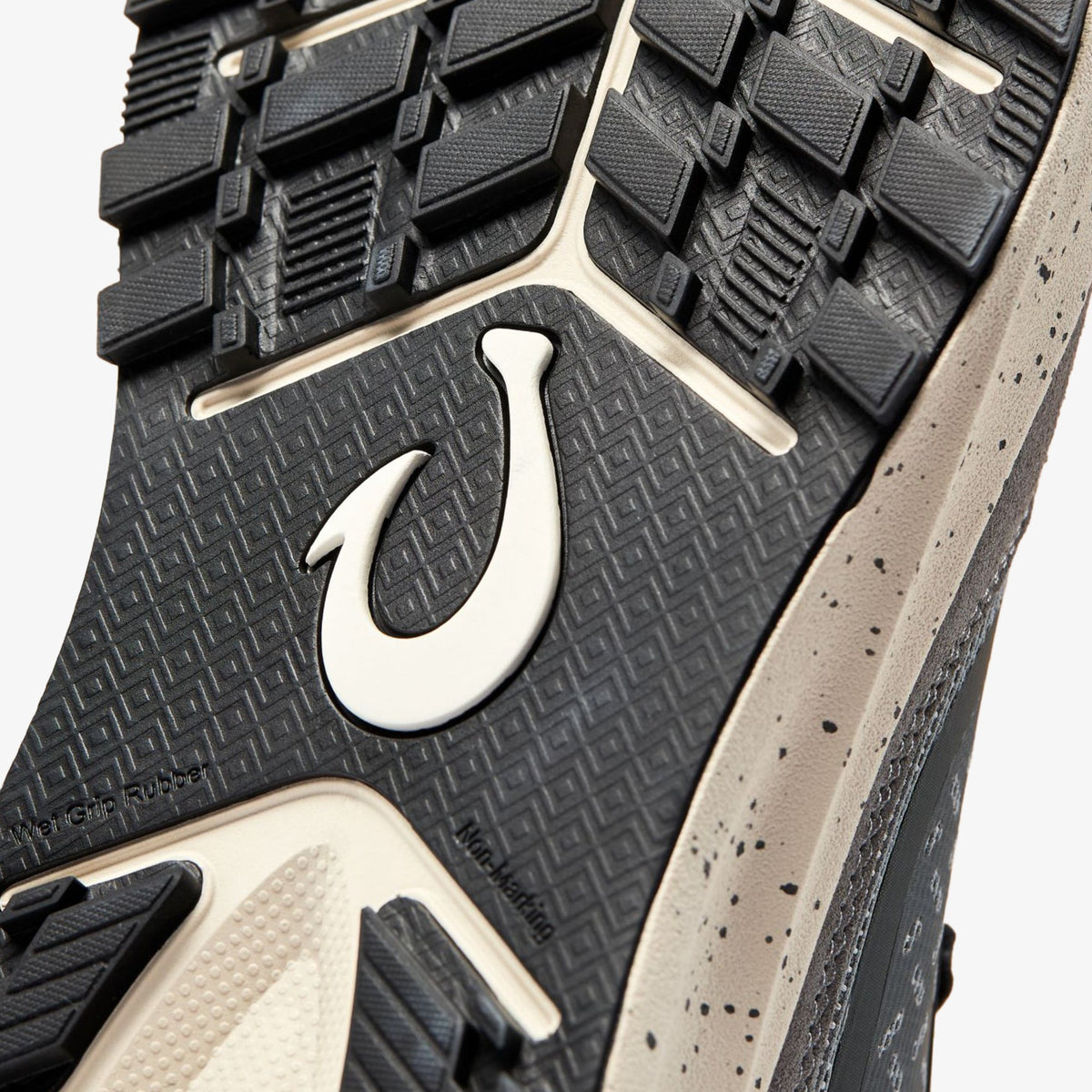 Black rubber sole with white hook logo, textured tread pattern, and grey speckled side panel.
