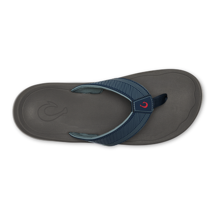 Dark gray thong sandal with blue striped webbing strap and red accent logo on the footbed, shown from above.