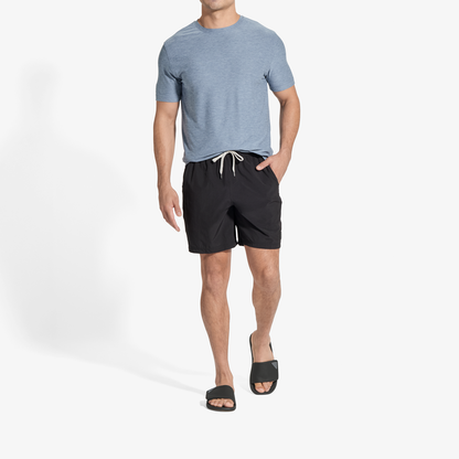 Man wearing blue-gray t-shirt, black shorts with drawstring, and black slides.