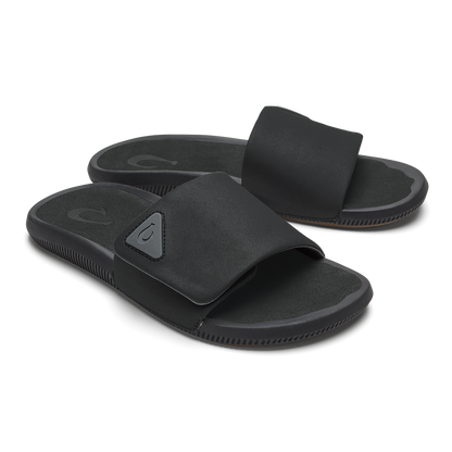 Pair of black slide sandals with textured straps and cushioned soles.