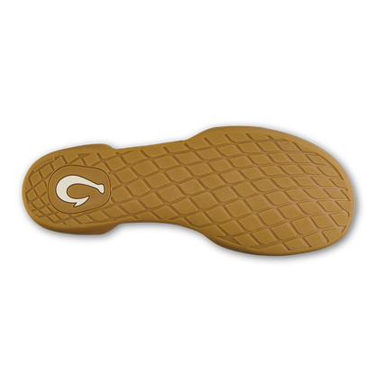 Tan rubber shoe sole with quilted tread pattern and white logo circle on heel.