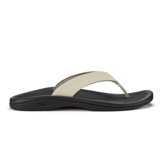 Ecru and black thong sandal with curved black sole and cushioned footbed.