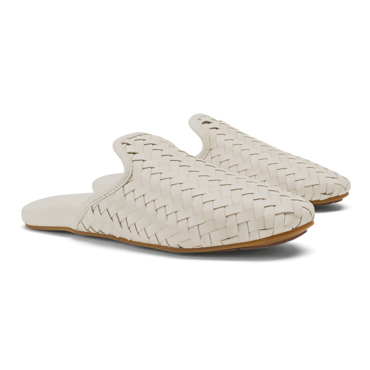 Pair of cream woven slip-on mules with tan sole and rounded toe.