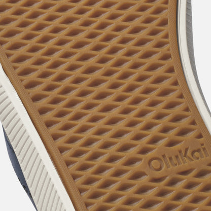 Tan waffle-textured sole with white and navy stripe, showing OluKai branding.