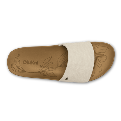 Tan slide sandal with cream crosshatch strap and embossed leaf design on footbed.