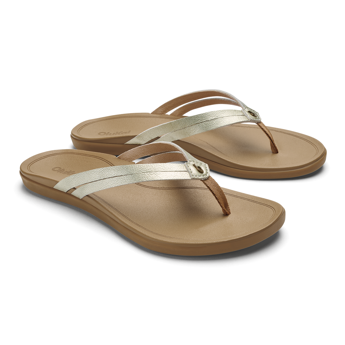 Pair of tan flip-flops with white and brown metallic straps and rounded toe posts.