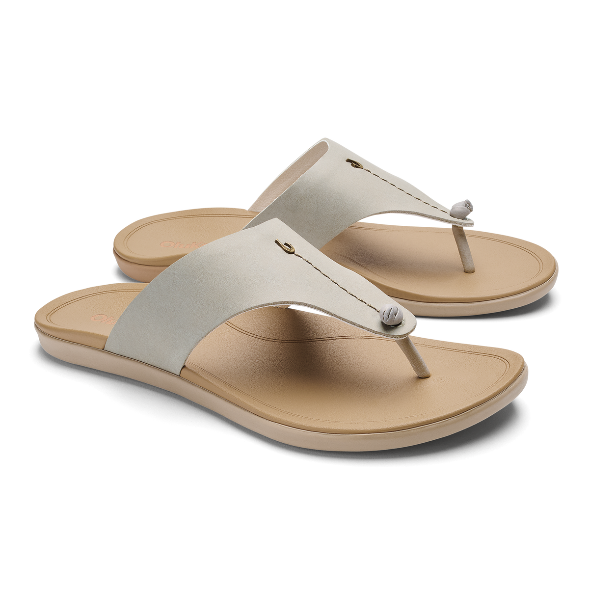 Pair of cream and tan thong sandals with padded fabric straps and cushioned soles.