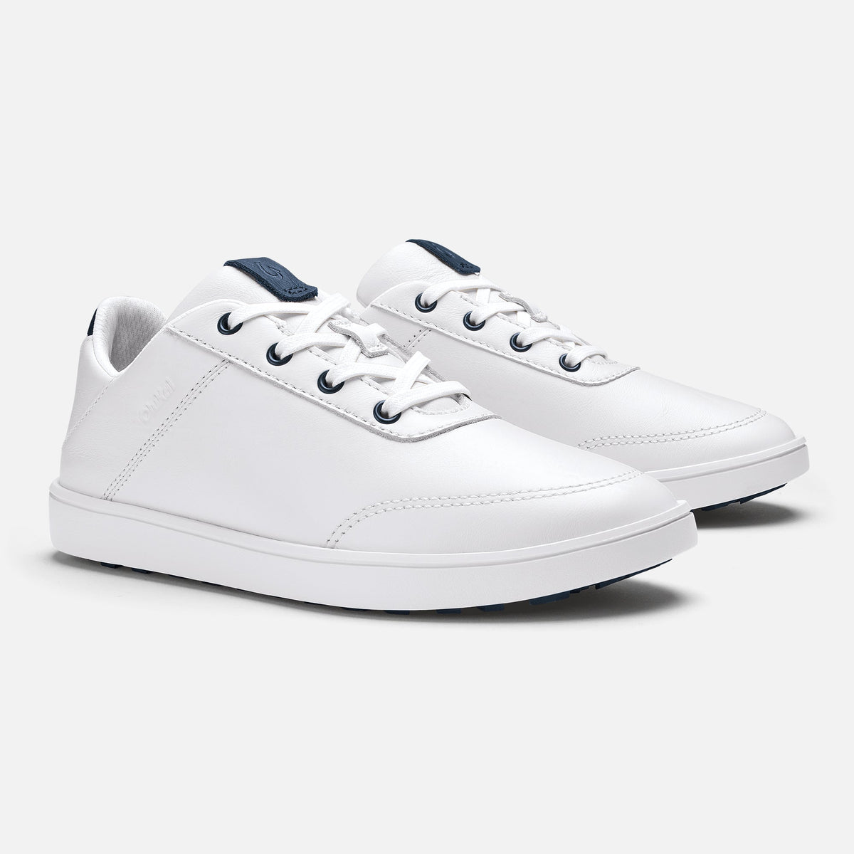 Pair of white leather sneakers with dark blue heel tabs and white laces.