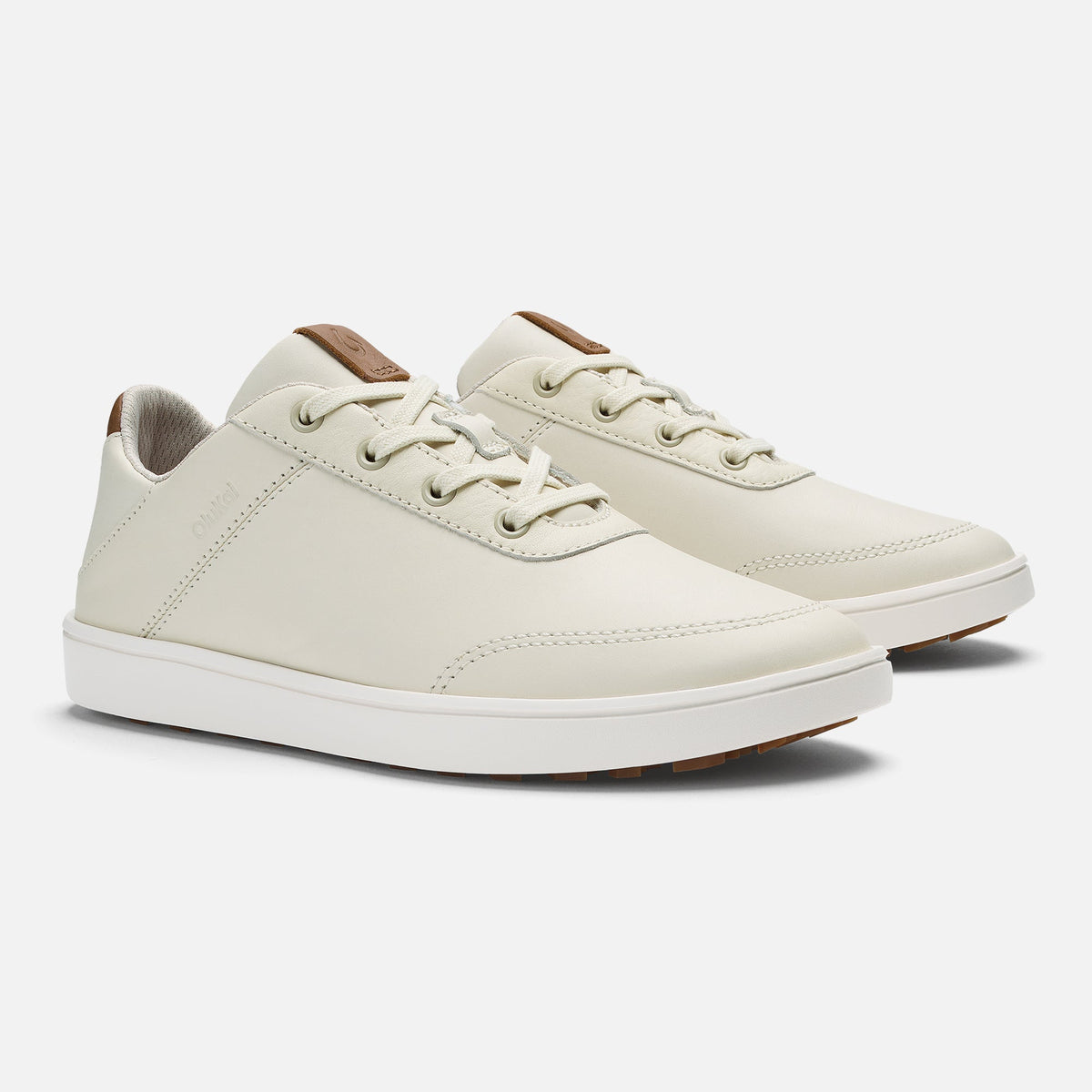 White and tan lace-up sneaker with brown heel tab and white sole, shown from the side.